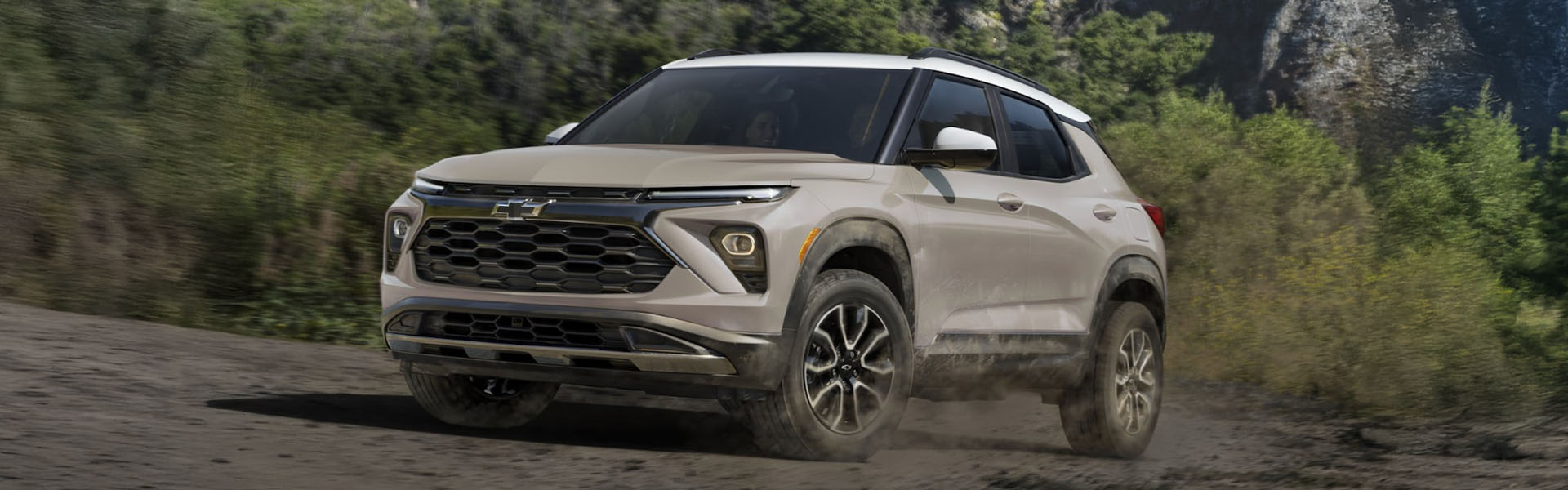 2026 Chevy Trailblazer compact SUV with modern exterior styling driving through an off-road landscape.